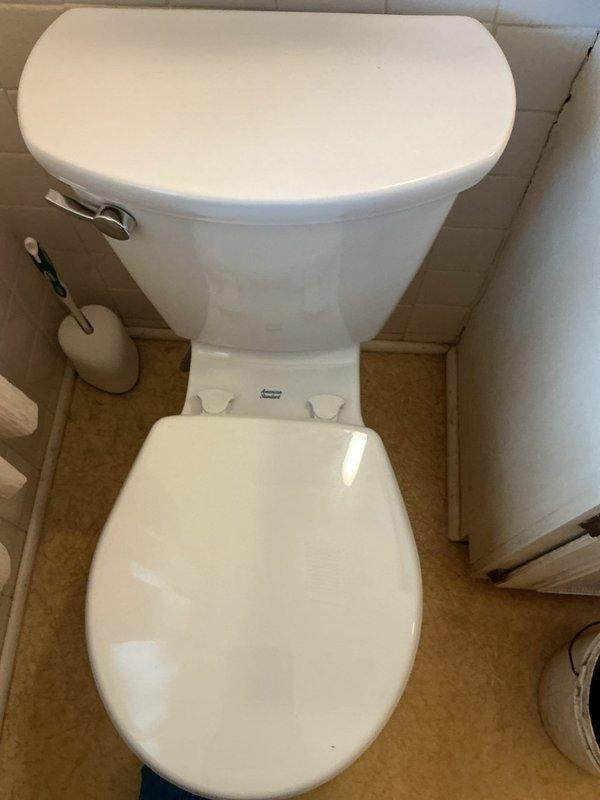 Removed existing toilet and installed new American Standard Cadet toilet in residential bathroom. Connected water supply line using braided metal flex hose with brass fittings to wall connection. Secured toilet to subfloor, tested flush mechanism and water supply valve for proper operation, and verified all connections were leak-free upon completion.