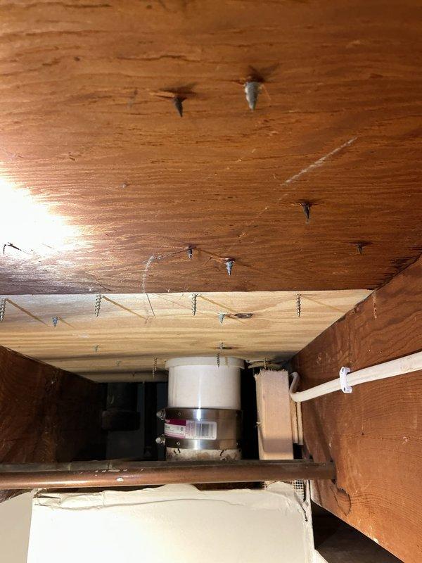 Responded to service call for slow draining toilet. Upon inspection, assessed plumbing drainage system from basement access point to identify cause of reduced flow. Examined waste line connections, floor joists, and drainage piping beneath fixture. Inspected water supply system and associated plumbing infrastructure to rule out secondary issues affecting toilet performance. Documented existing plumbing configuration including waste stack, supply lines, and mechanical connections for service records.