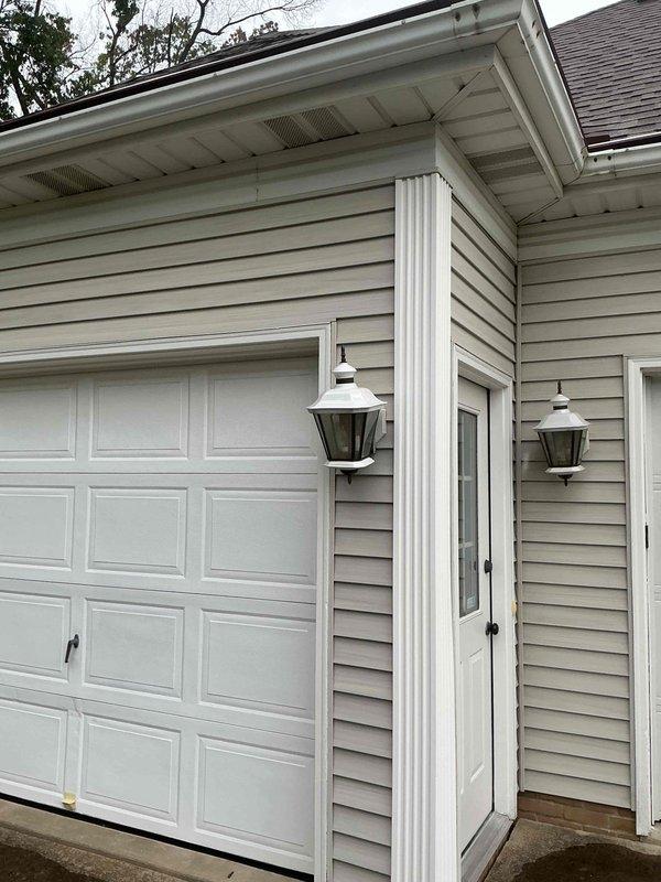 Removed existing weathered outdoor light fixture from front porch exterior wall and replaced with customer-supplied lantern-style fixture. Installed matching outdoor light fixtures on both sides of entry door adjacent to garage, ensuring proper mounting to exterior siding and secure electrical connections. All fixtures tested and verified operational upon completion.