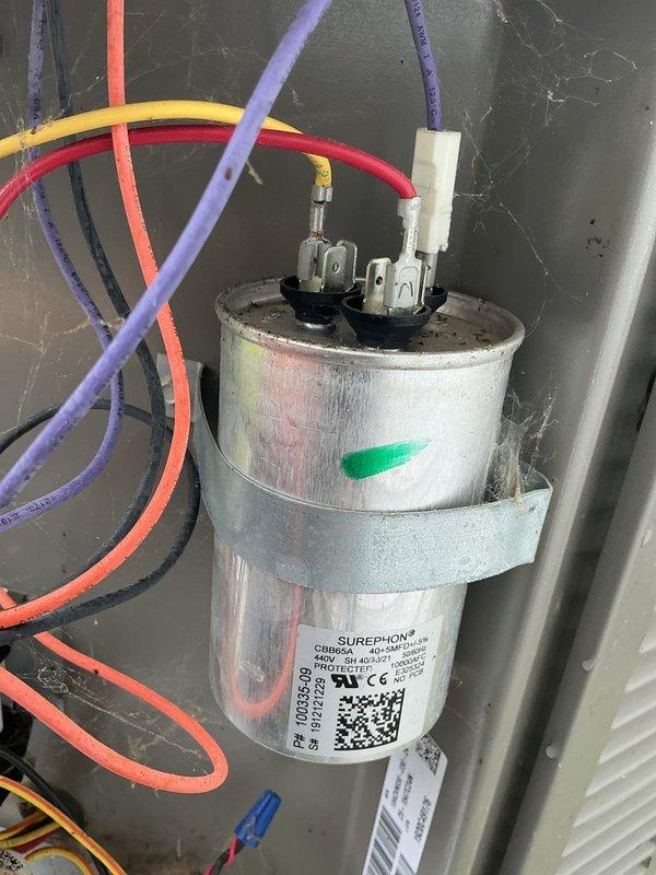 Completed comprehensive tune-up on 6-year-old air conditioning system. Inspected blower wheel assembly, noting dust accumulation on blades and housing; cleaned and verified proper operation. Tested dual-run capacitor with Surephon 440V unit showing proper connections across all terminals; confirmed electrical specifications within manufacturer tolerances and secure mounting bracket installation.