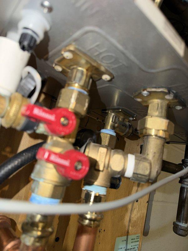Replaced the hot water outlet assembly on a Rinnai tankless water heater and performed complete descaling service to remove mineral buildup from the heat exchanger. Installed new brass fittings and connections, applied proper thread sealant, and verified all shut-off valves were functioning correctly. System was tested for proper operation, flow rate, and temperature output following the repair.