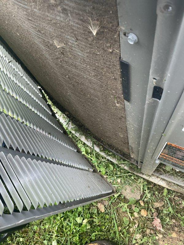 Completed scheduled maintenance visit on 7-year-old air conditioning system. Performed comprehensive inspection of outdoor condensing unit and control board assembly. Observed significant biological growth (algae and mildew) accumulation on condenser coil fins, particularly concentrated along bottom edges near ground level. Inspected ECN DRIVE 24V control board and verified all electrical connections, wiring terminals, and component integrity. Documented equipment condition with photographs for service records. Unit operational at time of inspection.
