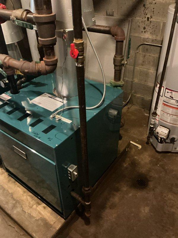 Coordinated commercial boiler installation with equipment and parts delivery to job site. Completed installation of boiler unit with copper piping connections, including horizontal and vertical runs with brass fittings and isolation valves. System tested and verified operational with all connections secure and properly configured in basement mechanical room.