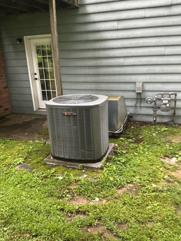 Completed full HVAC system installation including 90% efficiency Trane furnace and matching air conditioning condenser unit. Installed new furnace in basement mechanical room with proper venting using white PVC piping, connected refrigerant lines, and integrated digital control panel. Positioned outdoor AC condenser unit on existing pad adjacent to building structure, established electrical connections via wall-mounted panel, and verified proper gas line connections. All equipment tested and confirmed operational upon completion.