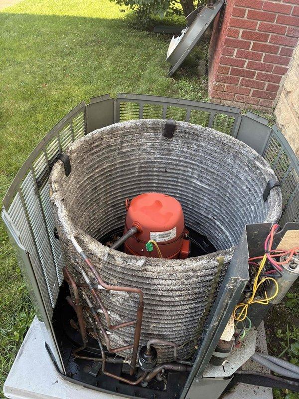 Completed MVP air conditioning maintenance service on outdoor condensing unit. Removed top cover to access internal components and inspected compressor assembly with cylindrical condenser coil, which showed significant accumulation of dust, dirt, and debris on metal fins. Cleaned coil surfaces to restore proper airflow and heat transfer efficiency. Verified refrigerant lines and electrical connections were secure and in proper working condition. Reassembled unit and confirmed normal operation upon completion of maintenance protocol.