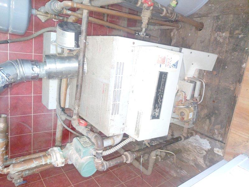Responded to no-heat call on residential boiler system. Upon arrival, confirmed pilot light was lit but unit was not producing heat. Diagnosed faulty circulator pump that was preventing proper water circulation through the heating system. Unplugged and tested pump, which initially kicked on but failed to maintain operation, indicating electrical or mechanical failure within the pump assembly. Identified that while the boiler's ignition system was functioning correctly, the lack of water flow prevented the unit from entering heating mode as a safety precaution. Noted significant mineral buildup and corrosion on copper supply piping and valve assemblies, indicating age-related deterioration of system components. Documented existing conditions including deteriorated pipe insulation and visible scaling on plumbing connections. Restored temporary pump operation to verify system functionality and confirmed boiler would fire once proper circulation was established.