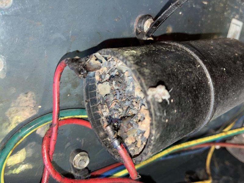 Completed scheduled MVP cooling maintenance visit. Upon inspection, discovered severe corrosion and electrical deterioration on motor capacitor and associated wiring connections. The capacitor exhibited extensive surface corrosion with flaky, grayish buildup indicating electrical failure. Connection points showed heavy oxidation and burned residue, presenting potential safety hazard and immediate failure risk. Component and surrounding area displayed significant dust accumulation and environmental degradation. Documented conditions with photographic evidence for service records. Recommended immediate replacement of affected capacitor and electrical connections to restore safe operation and prevent system failure.