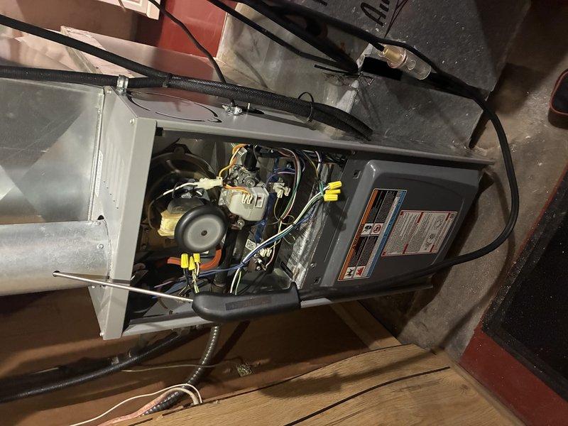 Completed MVP Cooling Visit performing comprehensive diagnostic testing and visual inspection of residential HVAC system. Utilized digital multimeter with clamp meter to measure electrical current draw on system components, confirming proper amperage readings at 0.58 amps on tested circuit. Removed access panel and inspected furnace internal components including blower motor assembly, electrical connections, wire terminations with wire nuts, control circuitry, and refrigerant lines. All components found operating within normal parameters with no deficiencies noted.