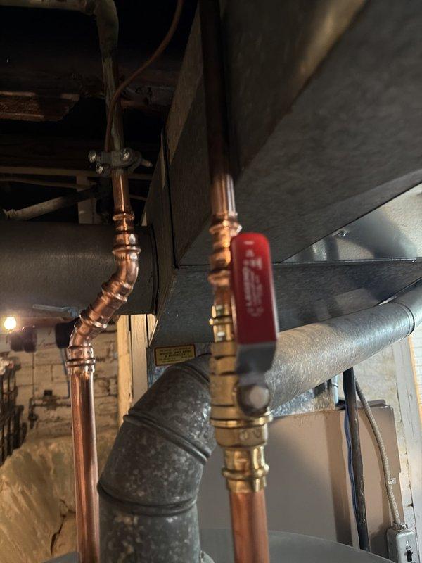 Successfully installed a 40-gallon hot water heater in the basement utility area. The installation included connecting copper supply lines with brass fittings and a red-handled ball valve for system isolation. All necessary parts from the water heater kit were utilized during the installation, and the unit was properly positioned and secured within the existing plumbing infrastructure alongside the HVAC ductwork system.