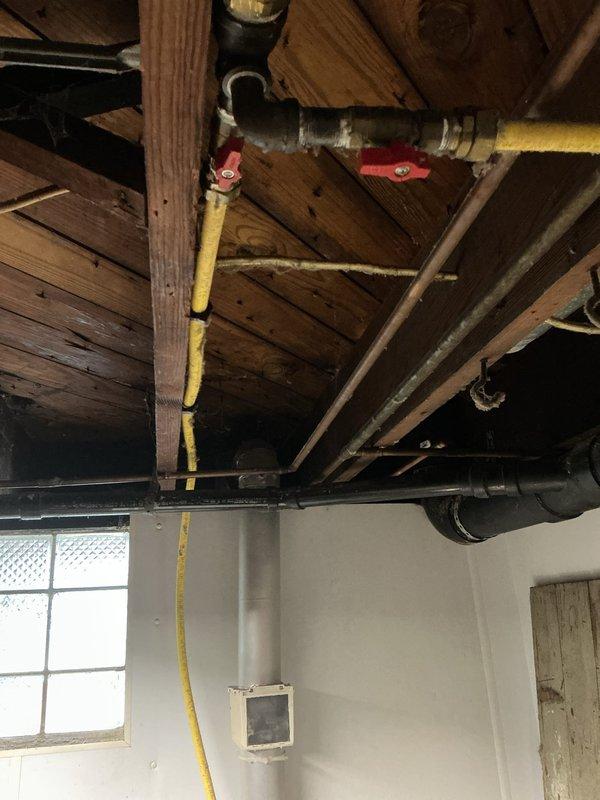 Installed new gas line for dryer connection in residential property. Ran yellow corrugated CSST gas line from main supply through basement ceiling joists to dryer location, securing line with appropriate metal clamps and fastening straps to structural members per code requirements. Completed all connections with proper fittings and verified installation meets safety standards for gas appliance operation.