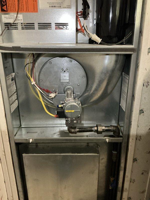 Responded to urgent callback for water discharge near HVAC equipment following previous service attempt. Upon inspection, documented interior components of heating system including gas valve assembly, blower motor, and cabinet configuration. Investigated source of water accumulation that intensified during AC operation to identify failed drainage or condensate issue requiring immediate attention.