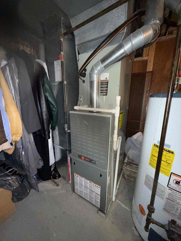 Completed MVP cooling maintenance visit on 12-year-old system. Upon inspection, discovered evaporator coil completely frozen with heavy ice buildup, indicating airflow restriction or refrigerant issue. Inspected indoor furnace unit and associated ductwork in utility area; noted system configuration and overall equipment condition. Addressed frozen coil condition and discussed outdoor unit cleaning requirements with customer per their original request, reviewing scope and pricing for exterior condenser cleaning services.