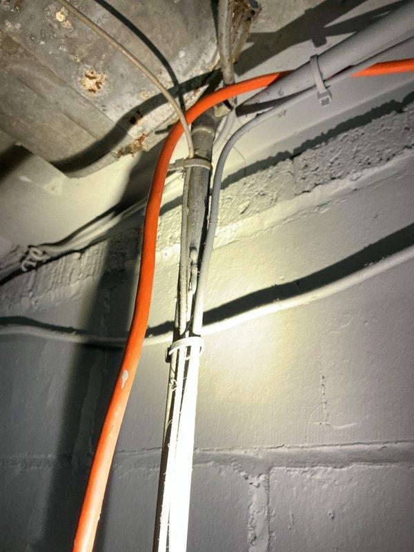 Completed comprehensive whole home plumbing inspection for recently purchased residence, including evaluation of hot water tank of unknown age. Documented existing plumbing infrastructure including under-sink drain trap with visible mineral buildup at connections, rigid metal supply lines, and flexible braided supply hose. Assessed basement utility area plumbing systems including PEX water lines, PVC drainage piping, and metallic piping with evidence of corrosion staining at ceiling penetrations. All accessible plumbing components photographed and evaluated for condition and compliance.