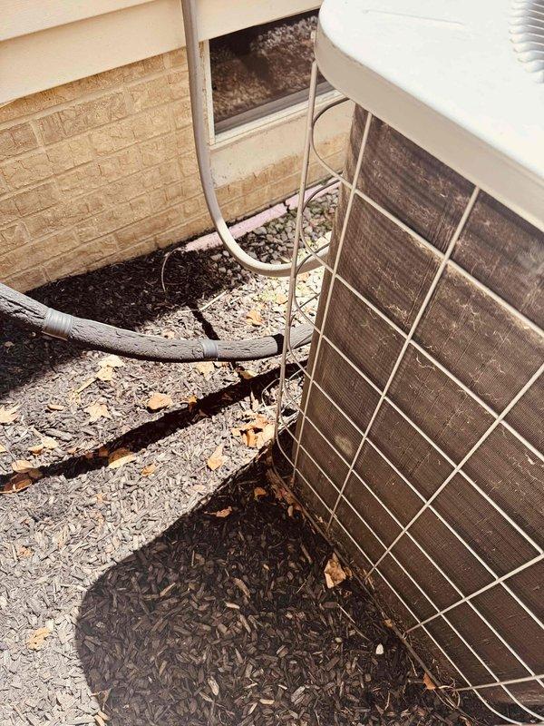 Responded to no cooling call on 20-year-old residential air conditioning system serving main level. Upon arrival, performed diagnostic evaluation of outdoor condensing unit and associated components. Unit showed signs of age-related wear consistent with equipment at end of expected service life. Documented current condition of system with photos showing outdoor unit placement, refrigerant line routing, and protective grille installation. Customer advised of findings and provided recommendations for system replacement due to age and efficiency considerations.