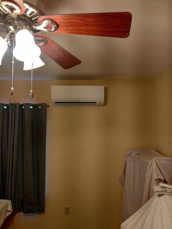 Completed installation of a 2-head ductless mini split system in residential property. Mounted indoor air handler units in two separate bedrooms, with one unit installed above bed area and second unit mounted on wall in adjacent bedroom. Established refrigerant line connections, electrical wiring, and condensate drainage for both zones to provide independent climate control for each room.