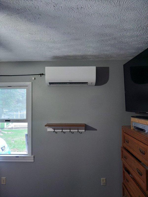 Completed installation of a 2-head ductless mini split system in residential property. Mounted indoor air handler units in two separate bedrooms, with one unit installed above bed area and second unit mounted on wall in adjacent bedroom. Established refrigerant line connections, electrical wiring, and condensate drainage for both zones to provide independent climate control for each room.