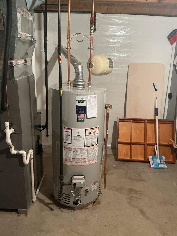 Installed 40-gallon water heater in basement utility area with all required code upgrades. Replaced existing unit with new water heater, connected copper supply lines and installed expansion tank, completed all plumbing connections per current code requirements. Installation included water heater kit components and necessary safety upgrades to bring system into full compliance.