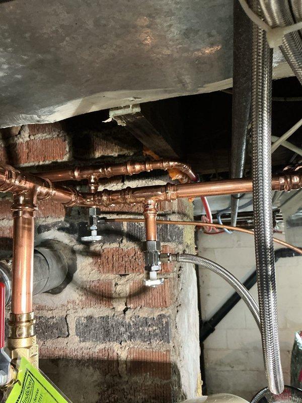 Installed a new 40-gallon Bradford White water heater with 8-year manufacturer warranty, including new ball valve and thermal expansion tank. Rebuilt water lines above the unit by removing the hot side shut-off and reconstructing with copper piping, replumbed 1/2" hot PEX line above the flue, and relocated the 1/4" shut-off for the humidifier. Replumbed 1/2" cold PEX line to eliminate two existing saddle valves and installed new dedicated shut-off valve for the ice maker line.