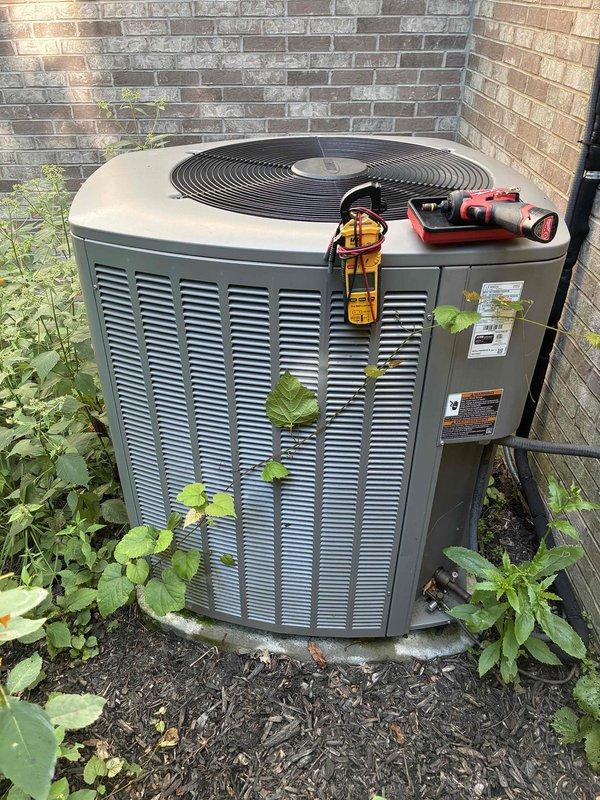 Completed preventive maintenance cooling visit on 7-year-old residential air conditioning system. Performed comprehensive electrical diagnostics using digital clamp meter to verify proper amperage draw and system voltage at outdoor condensing unit. Inspected all electrical connections within control panel, checking wire integrity and terminal tightness. All electrical parameters tested within manufacturer specifications with no abnormal readings detected. Noted vegetation growth around unit base and between louvers; cleared debris to ensure proper airflow and prevent future efficiency loss. Unit operating normally with adequate cooling capacity upon completion of maintenance service.