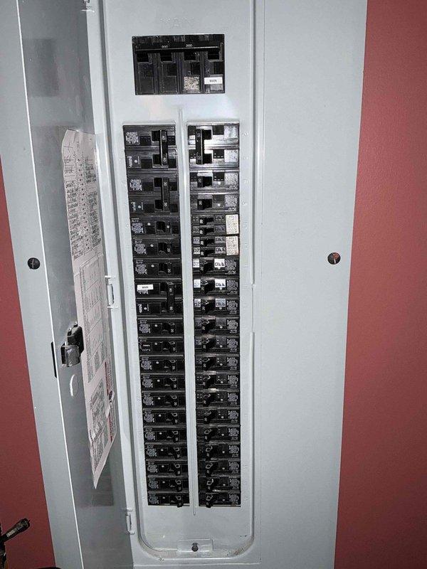 Conducted comprehensive electrical assessment for standby generator installation. Documented existing electrical panel configuration showing main breaker panel with dual columns of circuit breakers and secondary panel, including circuit directory for load calculation purposes. Evaluated attic space to determine optimal routing path for generator transfer switch wiring and conduit installation, noting existing electrical infrastructure, HVAC ductwork clearances, and insulation conditions that will impact installation methodology.