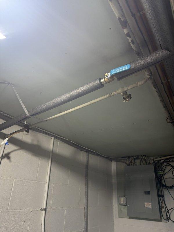 # Plumbing Service Completed

Responded to a comprehensive plumbing service call addressing multiple system issues throughout the property. Primary focus involved snaking the downspout drain to clear blockages and restore proper drainage flow. Removed a malfunctioning garbage disposal unit from the kitchen sink assembly. 

Inspected the tankless water heater and identified significant mineral buildup requiring descaling service to restore efficiency and proper operation. Noted the absence of a drain line installation for the temperature and pressure relief valve, which presents a code compliance concern.

Addressed basement plumbing needs by removing the existing toilet fixture and properly capping the drain line to prevent sewer gas infiltration and prepare the area for future use. 

Identified a leak in the cast iron stack line requiring repair to prevent water damage and maintain the integrity of the main drainage system. Documentation photos captured the utility area ceiling showin