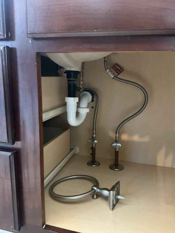 Replaced Kohler cartridge on right-side fixture assembly, addressing both hot and cold water control issues on three-piece deck-mounted faucet with white porcelain lever handles. Accessed supply lines through vanity cabinet, installed new cartridge components, and verified proper operation of both temperature control valves. All plumbing connections tested and confirmed leak-free upon completion.