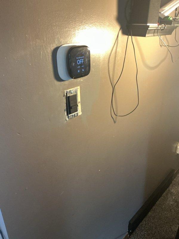 Installed electrical infrastructure for ceiling fan in residential room by tapping power from existing kitchen counter outlet on opposite side of wall. Ran switch leg from single gang box to attic, installed fan-rated junction box at ceiling location, and temporarily covered with blank plate pending homeowner's installation of fan fixture.