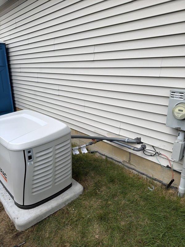 Completed installation of 10kW Generac standby generator system with 16-space automatic transfer switch. Ran 10 feet of electrical conduit from generator to transfer switch panel and 20 feet of gas line to fuel supply. Mounted transfer switch on interior wall with proper breaker configuration and wiring connections, installed generator on exterior concrete pad with weatherproof conduit runs to electrical meter and main service panel.