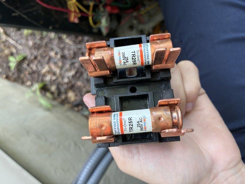 Completed routine BS-MVP cooling maintenance visit on 10-15 year old outdoor HVAC system. Inspected air handler interior, noting filter material with moderate dust accumulation consistent with normal operation. Examined and documented electrical fuses (TR25R 250A cartridge-style) removed from fuse block for inspection, showing typical wear and discoloration from service use. All components assessed for proper operation and system functionality verified.