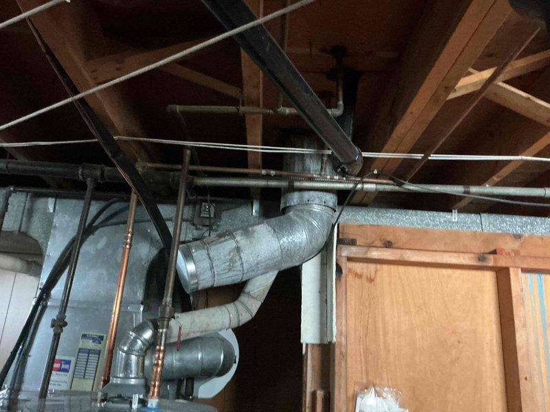 Responded to service call for reported furnace stack leak on 18-year-old heating system. Upon arrival, performed comprehensive visual inspection of furnace flue pipe assembly running from basement through attic to roof penetration. Examined all accessible sections of vent stack, including connections, joints, and support points throughout the vertical run. Inspected attic area where metallic ductwork and copper piping intersect with wooden structural members, checking for signs of moisture intrusion, condensation staining, or water damage on surrounding materials. Evaluated basement installation, including PVC drainage system and proximity to furnace exhaust components. Photographed critical areas showing vent configuration, pipe routing through floor joists, and overall system condition for documentation purposes. No active leaks observed during inspection period, though recommended monitoring during heating cycle operation to identify potential condensation issues that may occur unde