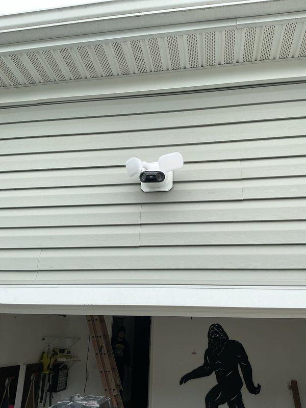 Installed new exterior flood light centered above garage door with dedicated switch control. Utilized existing attic access to fish new switch leg from 2-gang switch box to front of garage, then surface-mounted sealtite conduit to light location. Secured flood light fixture to customer-provided mounting plate and integrated new switch into existing wall box configuration. All wiring completed to code with proper connections established for independent flood light operation.