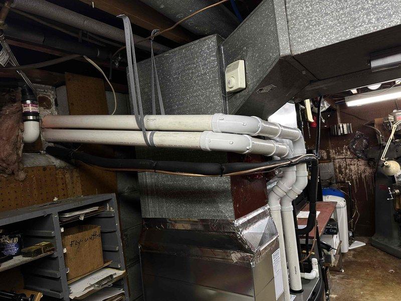 Completed rework of two flue pipes at front of Lennox furnace installation per customer specifications. Repositioned and secured white PVC condensate and vent piping with proper mounting brackets to improve aesthetic appearance and ensure proper drainage slope. All piping connections verified for proper sealing and compliance with manufacturer requirements.