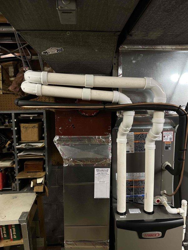 Completed rework of two flue pipes at front of Lennox furnace installation per customer specifications. Repositioned and secured white PVC condensate and vent piping with proper mounting brackets to improve aesthetic appearance and ensure proper drainage slope. All piping connections verified for proper sealing and compliance with manufacturer requirements.