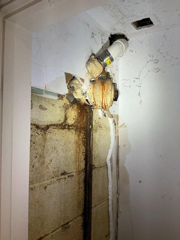 Responded to water leak originating from kitchen sink causing basement flooding. Upon inspection, identified compromised P-trap assembly and deteriorated supply line connections under kitchen sink with visible corrosion on shut-off valve. Documented extensive water damage to basement ceiling and walls, showing prolonged moisture intrusion with significant staining, surface deterioration, and structural compromise to drywall materials. Assessed plumbing configuration including PVC drain assembly, appliance connections, and supply lines to determine leak source and extent of damage requiring remediation.