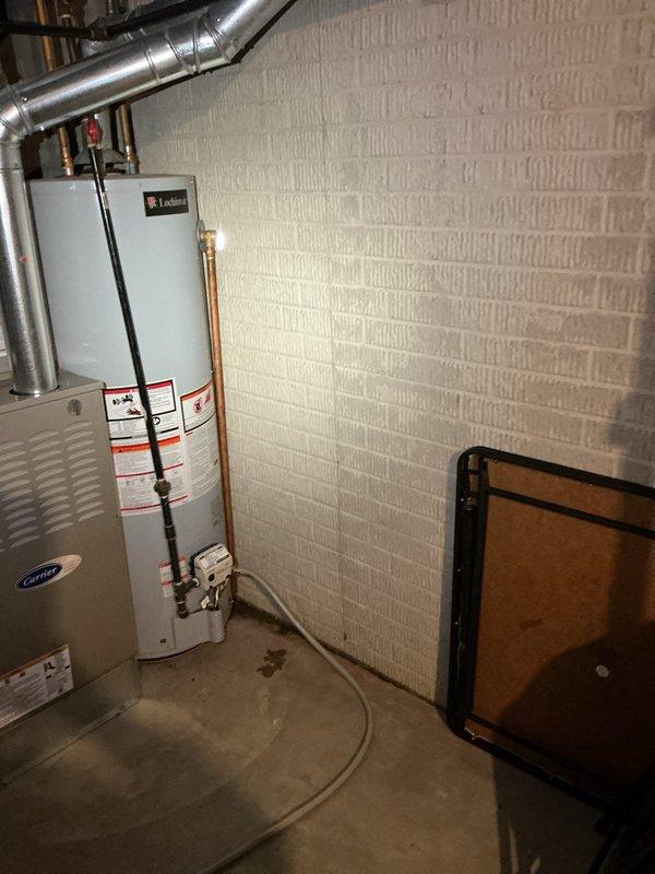 Provided no-cost estimate for replacement of existing 40-gallon natural gas atmospheric vented water heater experiencing active leak at base. Customer requested quote for upgraded 50-gallon capacity unit. Inspected current Lochinvar water heater installation in basement mechanical room, documented existing plumbing connections including copper supply lines with shutoff valves, confirmed natural gas supply line configuration, and assessed venting arrangement with existing galvanized ductwork system. Photographed equipment layout and surrounding HVAC components to ensure proper clearances and code compliance for replacement unit sizing and installation requirements.