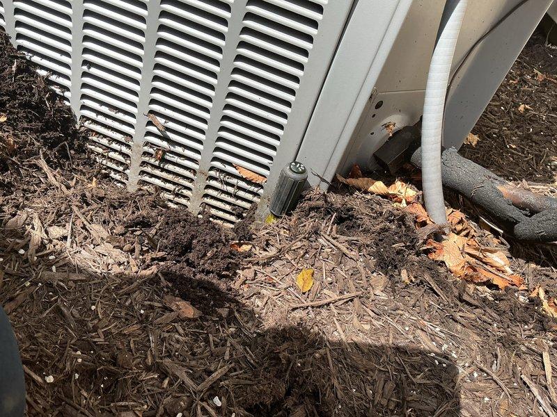 Completed maintenance tune-up on two 15-year-old outdoor AC units. Cleared significant accumulation of mulch, leaves, and organic debris from around and beneath both units to restore proper airflow and prevent potential drainage issues. Inspected refrigerant lines, verified proper connections, and ensured both systems were operating within normal parameters.