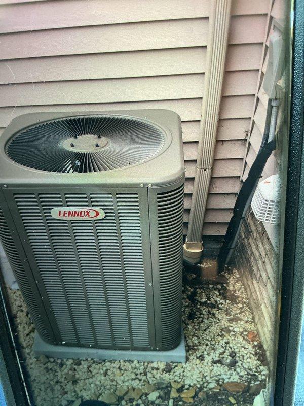 Completed BS-MVP cooling maintenance visit on 2-year-old Lennox air conditioning system. Performed standard preventive maintenance inspection of outdoor condenser unit and indoor air handler. Inspected air filtration system and noted pleated air filter showing moderate dust accumulation across surface, indicating normal usage since last service. Verified proper airflow direction marking on filter housing. Examined outdoor condenser unit positioned on concrete pad with decorative rock landscaping - unit operational with no visible damage to cabinet, fan grille, or refrigerant line set. All components functioning within normal parameters at time of inspection.