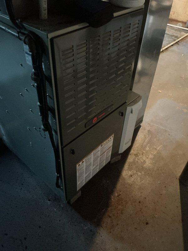 Completed MVP cooling maintenance visit on a 9-year-old residential air conditioning system. Outdoor condenser unit was accessed and inspected, revealing heavy accumulation of dirt, dust, and debris on the condenser coil that was significantly restricting airflow through the fins. Performed thorough coil cleaning to remove the matted debris layer and restore proper heat transfer efficiency. Inspected indoor Trane furnace unit and associated ductwork components for proper operation. System was tested and verified to be operating within normal parameters following maintenance procedures.