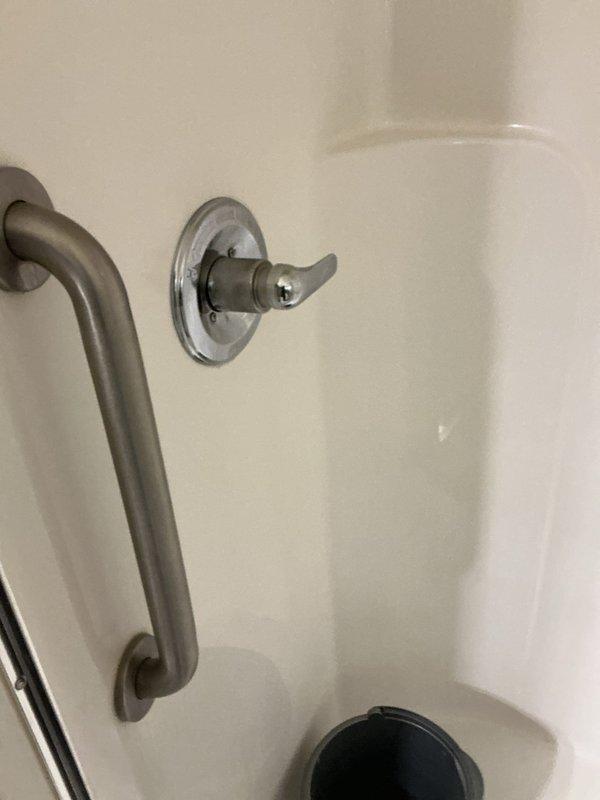 Responded to a leaking Delta Monitor shower valve in a bathroom of a home built in 1997. Accessed the valve assembly through the rear wall access point and inspected the brass cartridge and connections. Identified worn internal seals causing the leak, replaced the cartridge assembly, and tested the hot and cold water controls for proper operation. Verified all connections were secure and leak-free before closing the access panel.