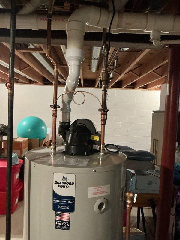 Removed and disposed of existing 50-gallon power vent water heater after shutting off gas and water supply and draining tank. Disconnected and preserved existing exhaust vent system for reuse. Installed customer-supplied 50-gallon Bradford White power vent water heater with new 3/4" water connections and replaced 1/2" gas union. Reconnected power vent exhaust system and reused existing 3/4" ball valve and bonding wire. Performed gas line leak test with all connections passing inspection. Filled tank, ignited burner, and set operating temperature to 120°F. Verified proper operation of all safety controls and venting system. One-year labor warranty provided on installation of customer-supplied equipment.