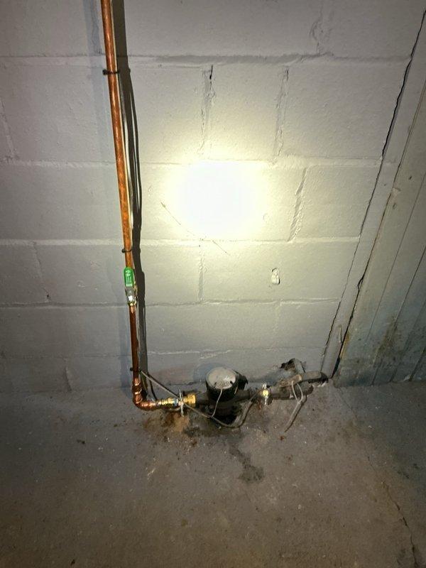 Conducted on-site assessment of existing residential water heater installation in basement utility area. Documented current unit condition, noting significant age-related deterioration including rust staining at tank base and general wear on exterior surfaces. Evaluated existing plumbing connections, including copper supply lines, brass shutoff valves, and pressure regulation equipment. Photographed water heater specifications, electrical connections, and mechanical infrastructure to determine replacement requirements. Assessed utility room layout, clearances, and access points for future water heater replacement installation.