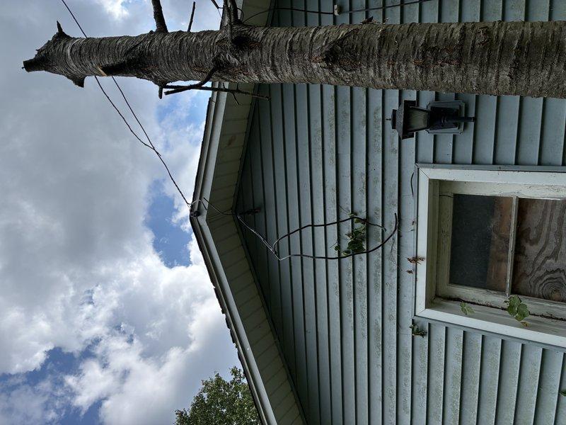Responded to no power call at residential property. Upon arrival, inspected exterior electrical service entrance and utility connection point on home with light green siding. Verified service drop connection and metering equipment. Proceeded to interior utility/workshop area to assess main electrical panel and distribution system. Inspected main service panel mounted on pegboard wall, checked breaker positions, and verified proper connections. Identified and resolved power issue, restoring electrical service to the residence. System tested and confirmed operational upon completion.