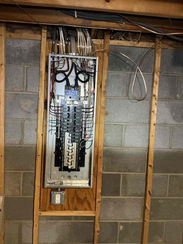 Conducted site assessment of unfinished basement electrical system to provide estimate for additional fixture installations and electrical work. Documented existing electrical panel configuration with multiple circuit breakers, assessed available capacity for new circuits, and evaluated current wiring infrastructure including conduit runs along ceiling joists. Identified optimal locations for potential new fixtures based on exposed framing structure and existing electrical pathways in preparation for detailed scope of work proposal.