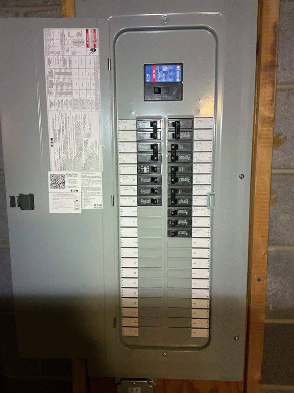 Completed 200A electrical service upgrade with full panel replacement and installation of exterior disconnect to meet 2023 National Electrical Code requirements. Installed new main breaker panel with digital monitoring display and properly organized circuit breakers in dual-column configuration. Corrected all circuit labeling with detailed directory information and QR code documentation affixed to panel door interior.