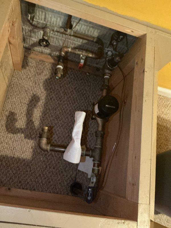 Completed electrical installation warranty inspection following successful approval. Accessed mechanical utility area through floor panel to document required water ground line and bonding connections per inspection requirements. Photographed copper water service piping, grounding electrode conductor connections, and bonding jumpers at water meter location. Documented all bonding connections to metallic water distribution system in accordance with NEC grounding and bonding standards.