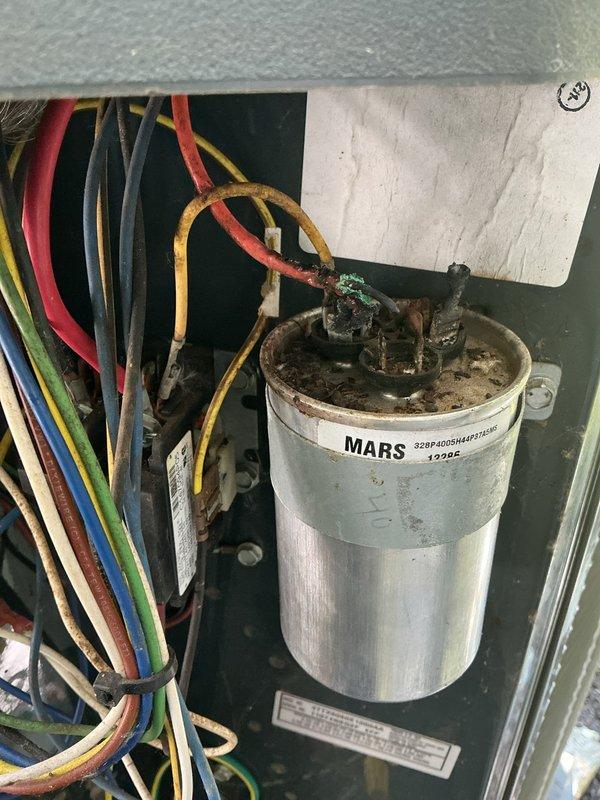Responded to no cooling/no airflow complaint on 15-year-old air conditioning system. Upon inspection, found failed blower motor capacitor with significant corrosion and deterioration at terminals. Replaced defective capacitor, verified proper electrical connections, and tested system operation. Unit restored to normal cooling function with proper airflow throughout.