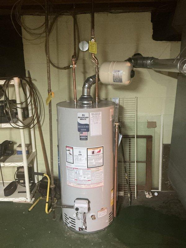 Replaced aging 25-year-old A.O. Smith 50-gallon water heater with new Bradford White 40-gallon short model featuring 6-year manufacturer warranty. Removed existing unit and installed replacement with complete code compliance upgrades including new cold water shut-off valve, electrical bonding wire, and thermal expansion tank. Rebuilt vent piping system to correct pitch issues caused by height differential of previous water heater. Connected all copper supply lines with proper shut-off valves and verified system pressure regulation. Tested all connections for leaks and confirmed proper operation of thermal expansion tank and venting system upon completion.