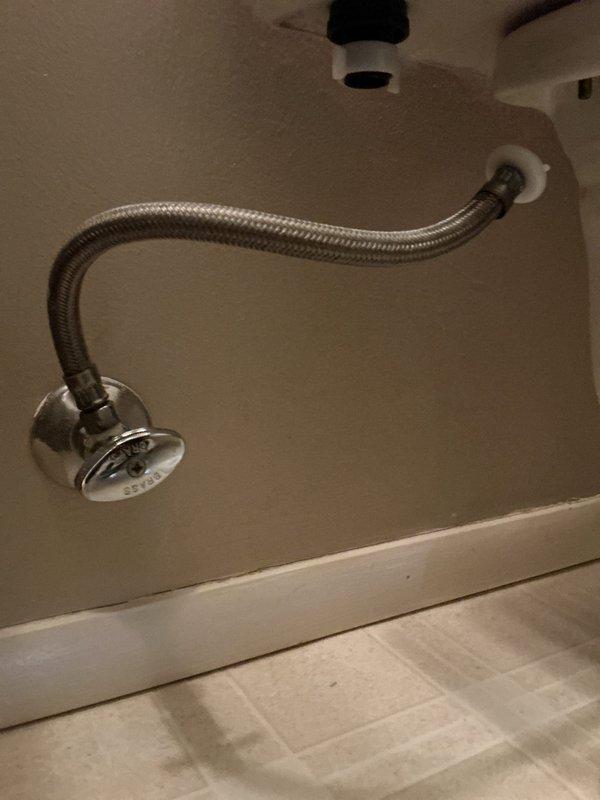Responded to emergency call for active water leak at toilet supply line in bathroom. Upon arrival, found main water supply had been shut off by homeowner to stop continuous spray from failed shutoff valve connection. Inspected the toilet water supply system and identified compromised angle stop valve and deteriorated braided stainless steel supply line requiring immediate replacement. Removed old valve and supply line, installed new chrome-finished angle stop valve with proper wall escutcheon, and connected new flexible braided stainless steel supply line from wall valve to toilet tank inlet. Restored main water supply, pressurized system, and conducted thorough leak check at all connection points including wall valve, supply line couplings, and tank inlet. Verified proper water flow and shutoff valve operation. Cleaned work area and removed all debris. System tested and confirmed fully operational with no leaks detected.