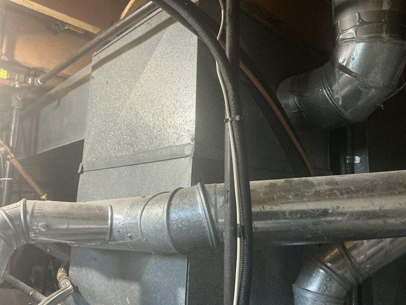 Conducted comprehensive assessment of existing basement HVAC system for medium-sized residential property requiring heating and cooling replacement. Evaluated current natural gas furnace and air conditioning infrastructure, including air handler unit, ductwork configuration, and ventilation components. Documented existing equipment layout showing aged metal ductwork, plumbing connections, and electrical conduit routing in mechanical room. Provided estimate for Lennox vertical upflow/downflow gas furnace and air conditioning system sized appropriately for 1500-3000 square foot application, accounting for basement installation requirements and existing utility connections.