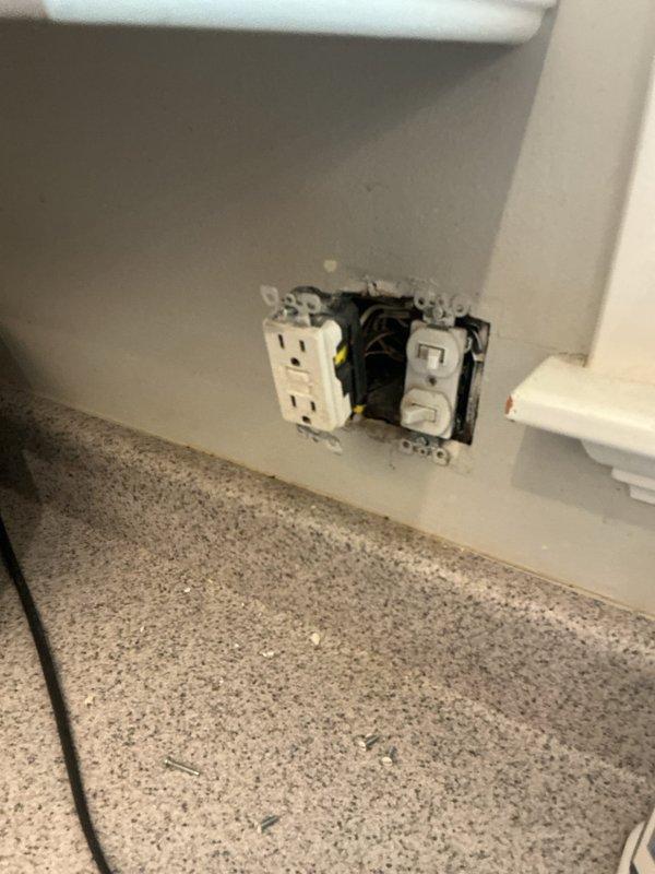 Responded to a non-functioning GFI outlet near the kitchen sink that was not responding to breaker resets. Upon arrival, inspected the outlet and switch combination plate mounted on the wall above the granite countertop. Removed the cover plate and pulled the devices forward to access the electrical box and internal wiring connections. Identified faulty wiring connections within the junction box as the root cause of the power loss. Verified all wire connections including hot, neutral, and ground conductors, ensuring proper termination and secure attachment to the GFI receptacle. Tested the circuit for proper voltage and ground fault protection functionality. Reinstalled the outlet and switch devices, secured them to the wall box, and replaced the cover plate. Confirmed restoration of power to the GFI outlet and verified proper reset functionality.